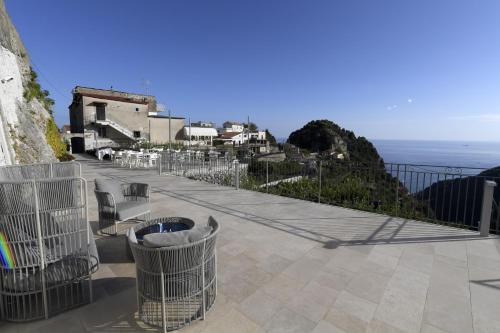 a balcony with chairs and a view of the ocean at Palazzo San Giovanni Amalfi Coast in Scala