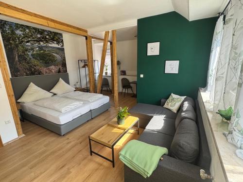 a living room with a couch and a bed at Mosel-Landhaus Hotel Oster in Ediger-Eller