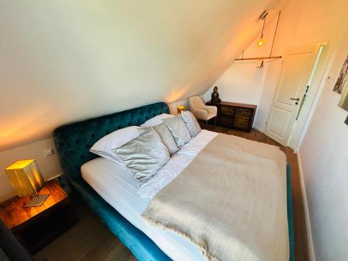a bed with a blue headboard in a bedroom at Wohnung Hafenblick in Zingst