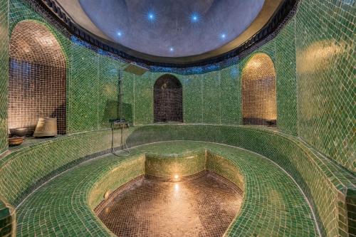 a large green tiled room with a large pool of water at Villa Hiba Luxury & Paddle in Najem