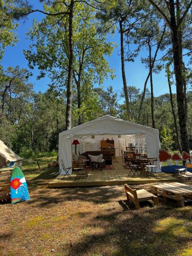 une tente blanche avec des tables et des chaises dans un champ dans l'établissement Le Spot La Tranche sur mer, à La Tranche-sur-Mer