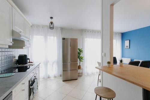 une cuisine avec un réfrigérateur et un plan de travail dans l'établissement Grand Appartement 4chb centre-ville 8-10 personnes, à Troyes