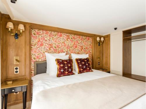 une chambre avec un grand lit blanc avec un mur rouge dans l'établissement Merveil - Luxury Suite - Marais - Turenne, à Paris