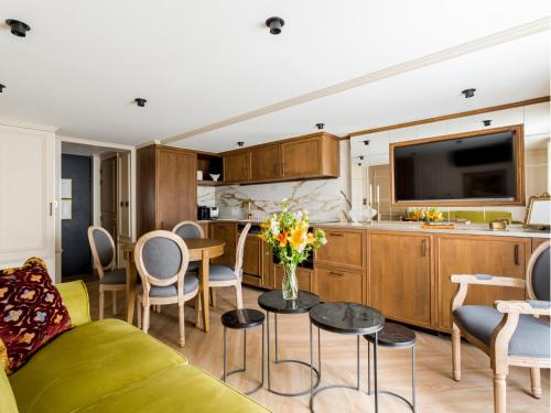 un salon avec un canapé et une cuisine dans l'établissement Merveil - Luxury Suite - Marais - Turenne, à Paris