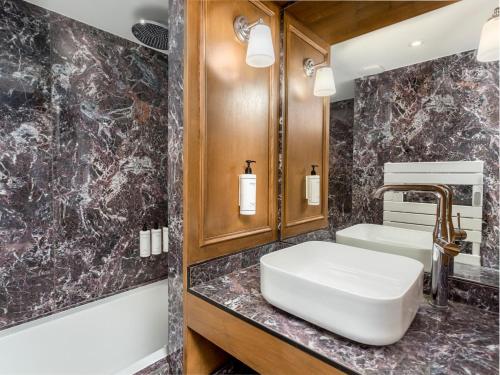 une salle de bain avec un lavabo et une baignoire dans l'établissement Merveil - Luxury Suite - Marais - Turenne, à Paris