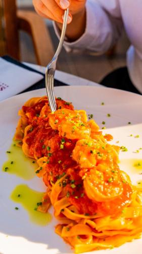 a person eating a plate of pasta with a fork at Sky Boutique Hotel in Perea