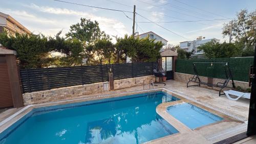 a swimming pool in the backyard of a house at Villa Didim in Didim