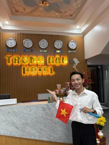 a man holding a chinese flag in a hotel room at Trung Hau Hotel in Can Tho