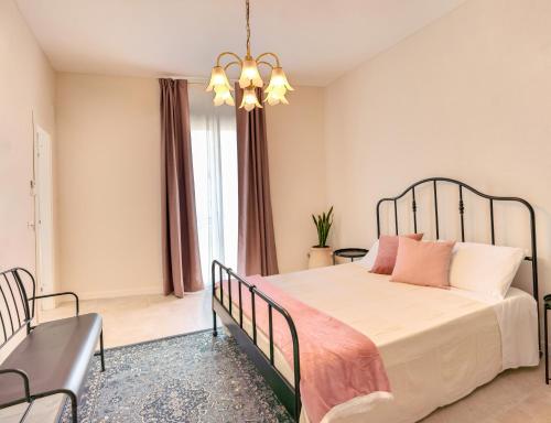a bedroom with a bed and a chandelier at Vico Larzio 6 "Terrazza sul Vico" in Noto