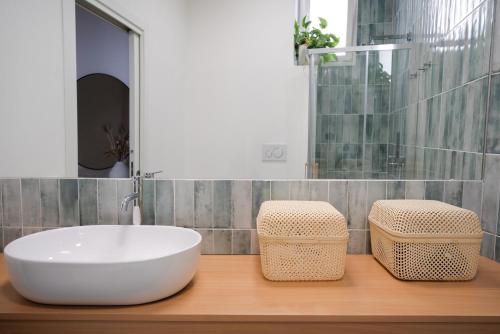 a bathroom with a white tub and two wicker stools at Vico Larzio 6 "Terrazza sul Vico" in Noto