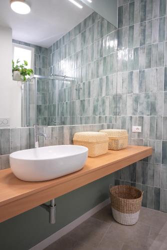 a bathroom with a white sink on a wooden counter at Vico Larzio 6 "Terrazza sul Vico" in Noto