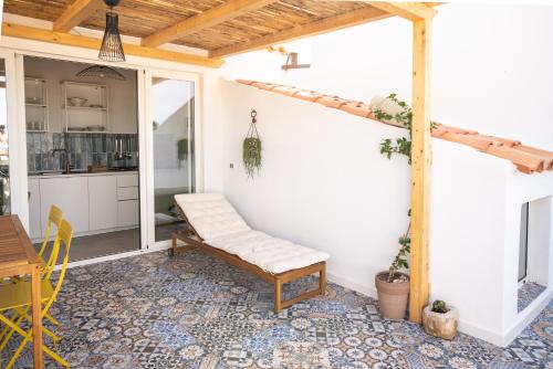 a patio with a bench and a table at Vico Larzio 6 "Terrazza sul Vico" in Noto