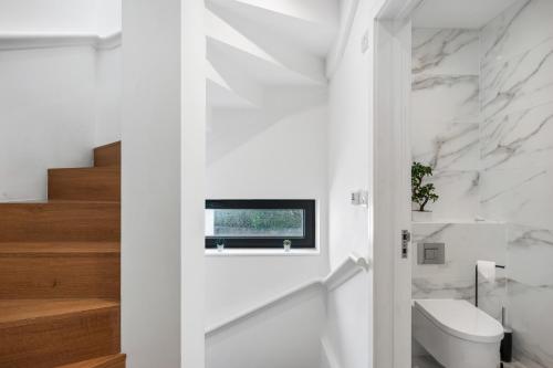 a bathroom with a toilet and a tv on the wall at Bright and Modern 3 bed Seaside escape sleeps 5 in Brighton & Hove
