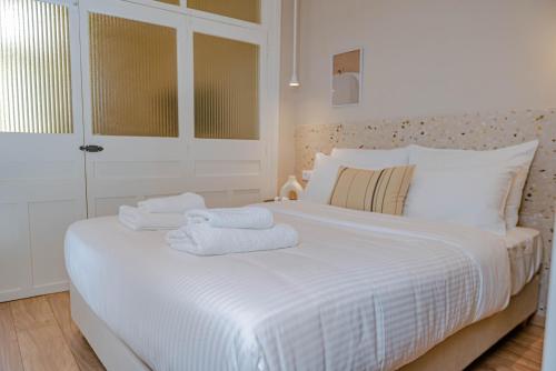 イラクリオン・タウンにあるTerrazzo City Aptsのタオルが敷かれた白いベッドのある寝室
