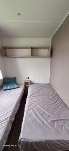 Cette chambre comprend deux lits. dans l'établissement Mobil home 6 pers - Camping 4 étoiles - Sarzeau, à Sarzeau