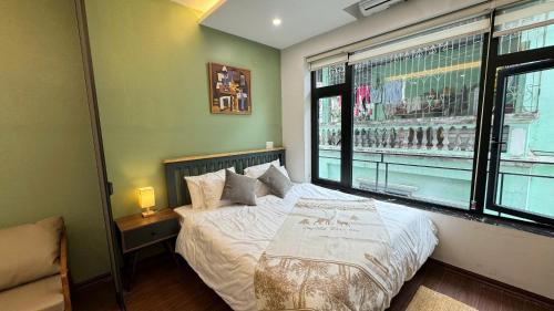 a bedroom with a bed and a large window at Apartment in Ho Tay in Hanoi