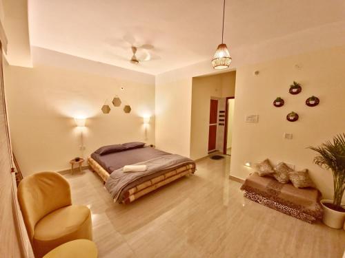 a bedroom with a bed and a chair and a couch at Amaar Ghar in Guwahati