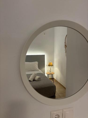 a bedroom with a bed and a round mirror at Sea Wind Villas and Suites in Tourlos