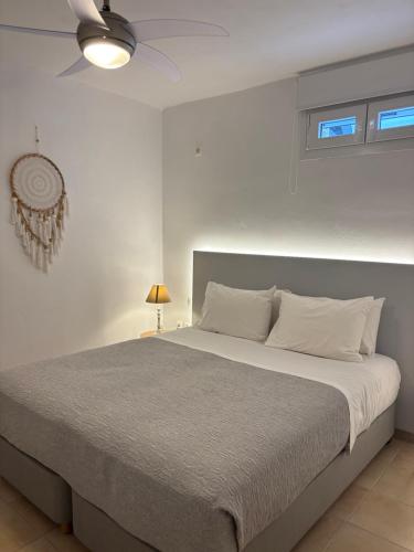 a bedroom with a large bed with a ceiling fan at Sea Wind Villas and Suites in Tourlos