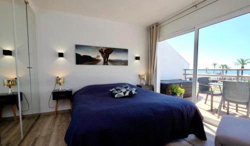 a bedroom with a blue bed and a large window at Apartamento con Vistas al Mar in Empuriabrava