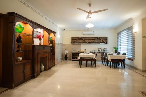a dining room and kitchen with tables and a ceiling fan at Ahuja Residency Cyber City I in Gurgaon