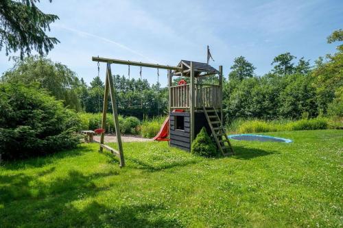 a playground in a field with a swing at Studio lodge de Bosuil bij Bolmeer Lodges in Zevenhuizen