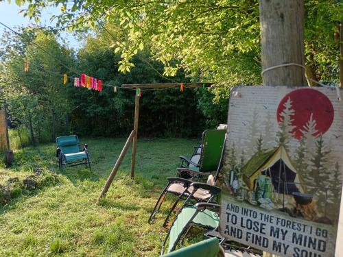 a sign sitting next to a tree with a tent at Camere nel bosco sulla Via Francigena in Monteriggioni