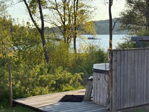 a wooden deck next to a body of water at Hällesdalens Gård - semesterhus i Bohuslän in Svenshögen