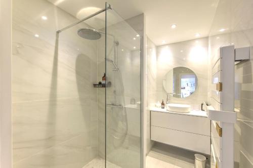 une salle de bain blanche avec une douche et un lavabo dans l'établissement Choncara, à Arcachon