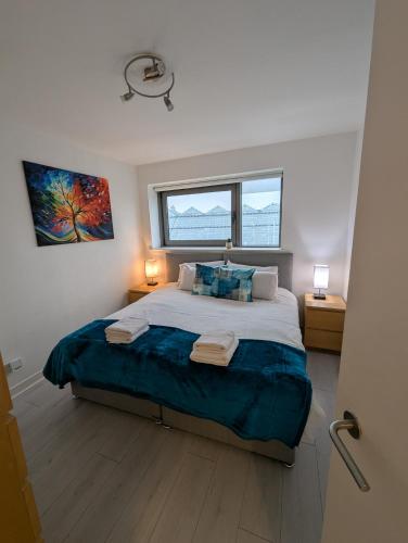 a bedroom with a large bed with two night stands at Glasgow City Centre Waterfront Apartment in Glasgow