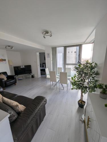 a living room with a couch and a table at Glasgow City Centre Waterfront Apartment in Glasgow