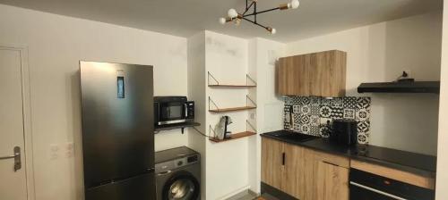 une cuisine avec un réfrigérateur et un micro-ondes dans l'établissement Appartement cosy à Chartres avec balcon de 50 m², à Chartres