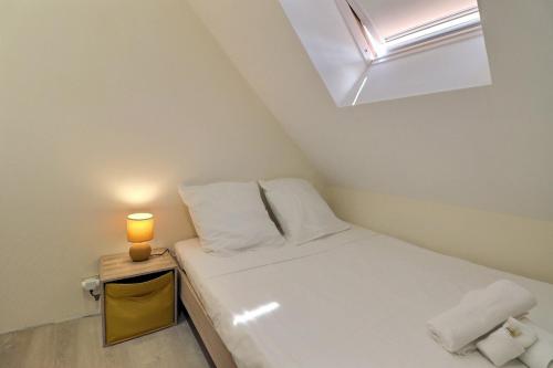 - une petite chambre avec un lit éclairé dans l'établissement L'Appart de la Pierre - Idéla Pro - Centre Ville - Proche Gare - Mon Groom, à Troyes