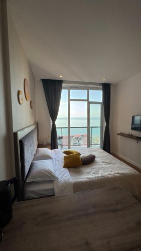 a bedroom with a large bed with a large window at Hedi 18 Apartment in Batumi