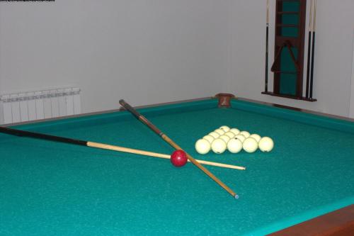 a pool table with two cue sticks and balls on it at Ani Resort in Artavaz