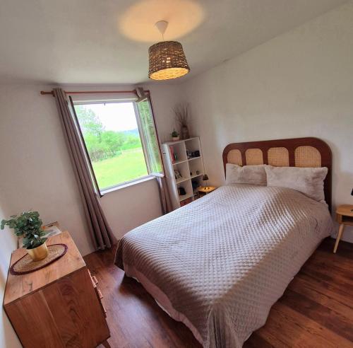 une chambre avec un grand lit et une fenêtre dans l'établissement La Planchotte, à Peigney