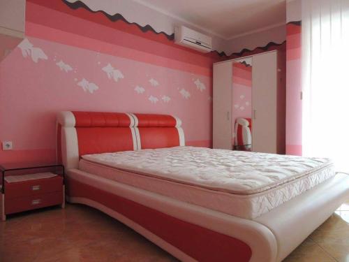 a bedroom with a large bed with pink walls at Apartmani Niksic in Herceg-Novi