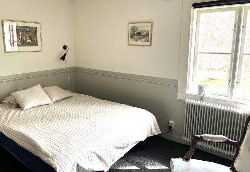 a bedroom with a bed and a window and a radiator at Tranås Vandrarhem in Tranås