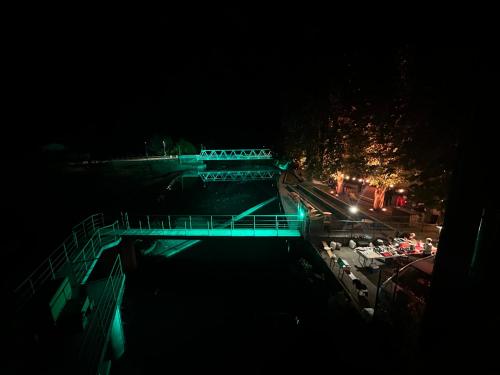 a bridge over a river at night with green lights at PERLE d ARCONI in Renče