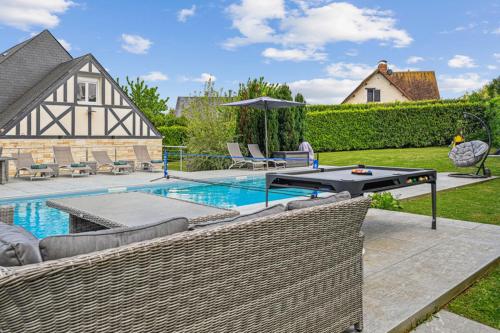 une cour avec une piscine, une table et des chaises dans l'établissement House Deauville - Splendid luxury home, à Saint-Arnoult