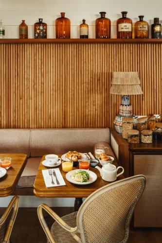 a dining room with a table with food on it at La Mission Hôtel & SPA - l'île d'Yeu in L'Ile d'Yeu