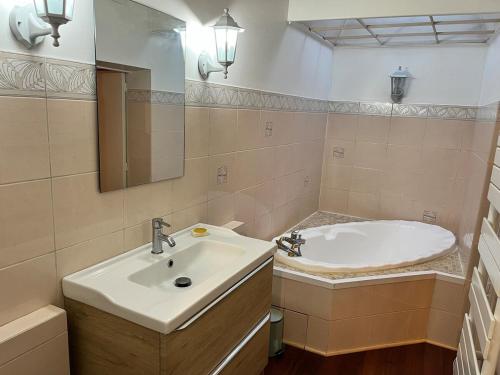 une salle de bain avec un lavabo, une baignoire et un miroir dans l'établissement Gite du Clocher de la Cathédral charmant duplex, à Périgueux