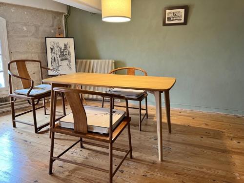- une table et des chaises en bois dans l'établissement Gite du Clocher de la Cathédral charmant duplex, à Périgueux