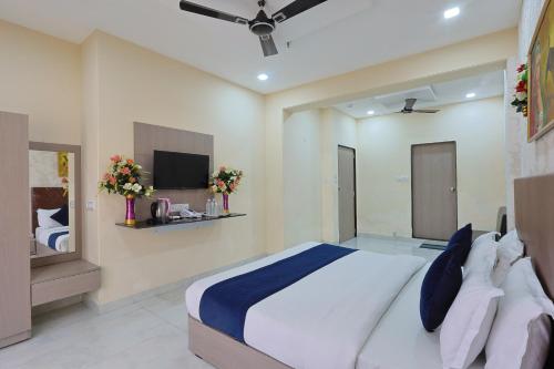 a bedroom with a large bed and a tv at The Castle Crown - Hotel Lord Krishna Dham in Dwarka