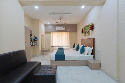 a hotel room with a large bed and a couch at The Castle Crown - Hotel Lord Krishna Dham in Dwarka