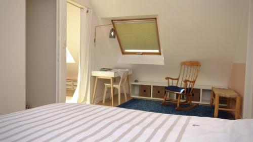 une chambre avec un lit, un bureau et deux chaises dans l'établissement Kercolette, maison avec piscine non chauffée proche des plages, à Erdeven