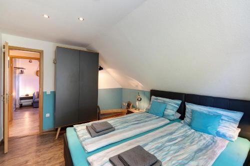 a bedroom with a large bed with blue pillows at Ferienhaus Ankerglück in Lensahn