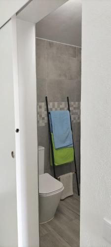 a bathroom with a chair next to a toilet at Sol e Praia Alvor 1 in Alvor