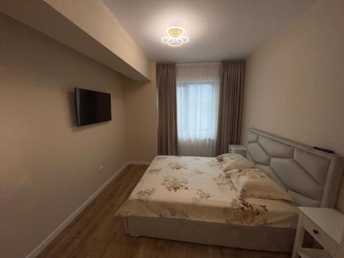 a small bedroom with a bed and a television at Ayan Mamaia in Mamaia Nord