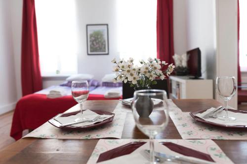 una mesa con dos copas de vino y un jarrón de flores en Old Vienna Apartments, en Viena